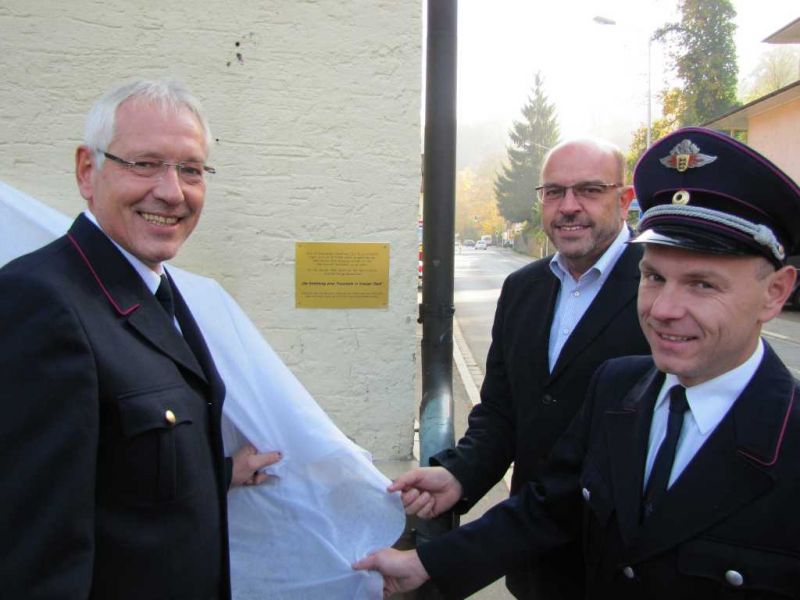 Stadtbrandmeister Reinhold Albrecht, Oberbürgermeister Heiner Bernhard und Abteilungskommandant Patrick Müller enthüllen die Gedenktafel